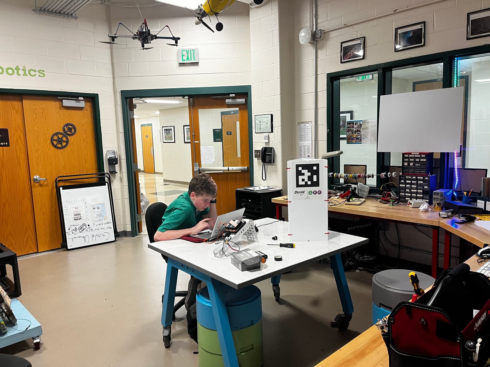 A laptop showing AprilTag detection code next to the robot