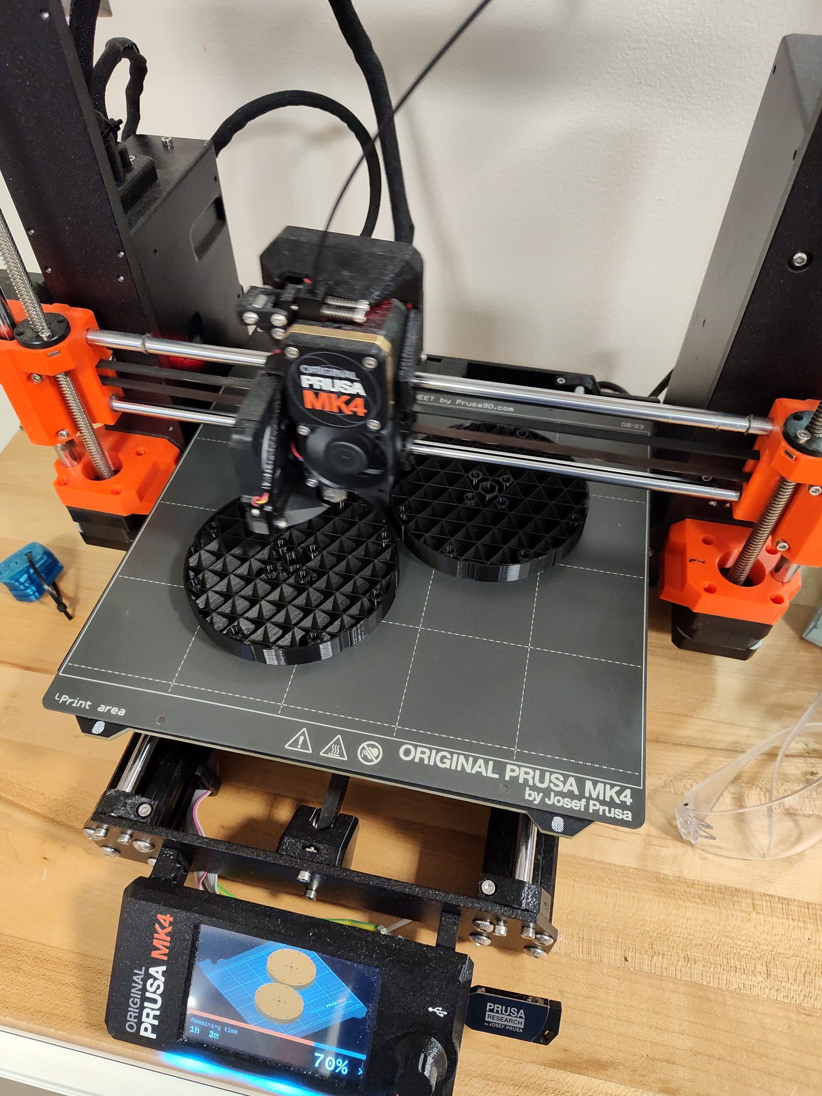 A 3D printer printing black compliant wheels