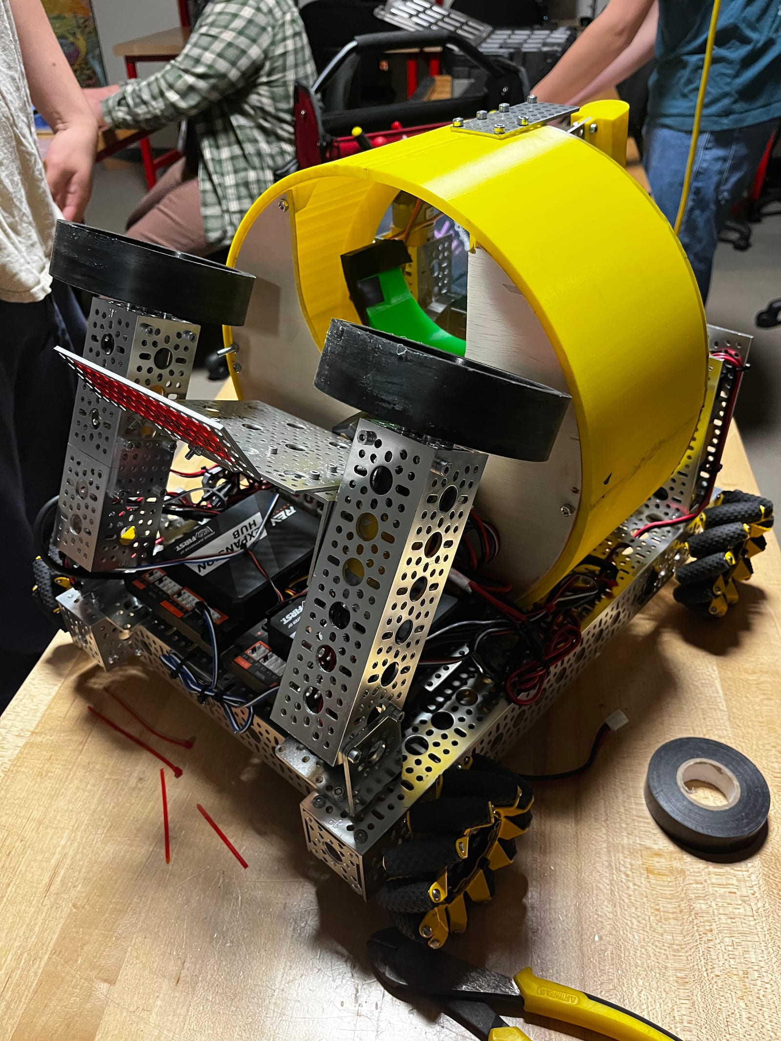 The robot on a workbench with its yellow drum and launcher wired up