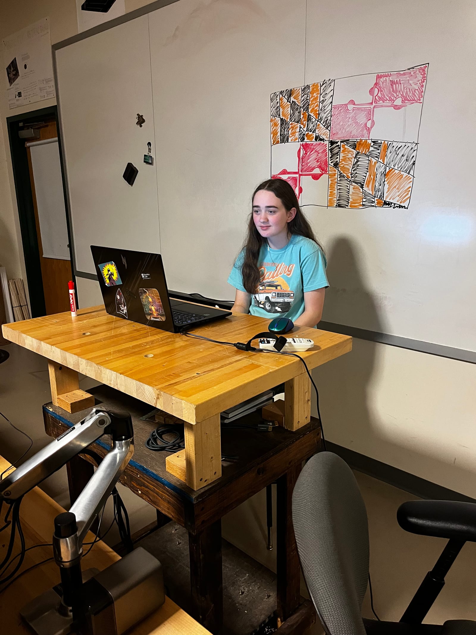 A student at a laptop on a video call in the shop